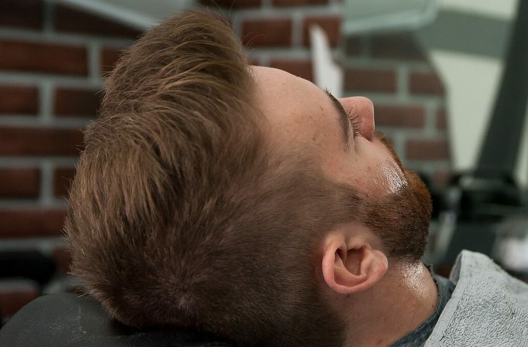 homme se faisant tailler la barber chez le barbier